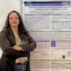 Dra. Michelle Sabrina da Silva ao lado do pôster do estudo sobre ácido glioxílico no CBTOX 2026.
